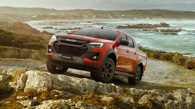 A volcanic amber D-MAX driving on sand