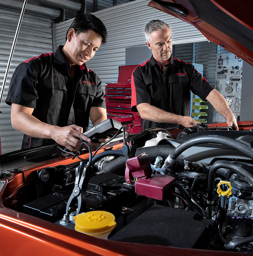 Two Isuzu Ute Service Plus technicians service the engine of an Isuzu Ute
