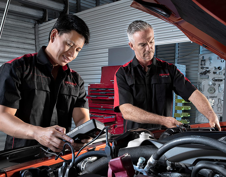 Two Isuzu Ute Service Plus technicians service the engine of an Isuzu Ute